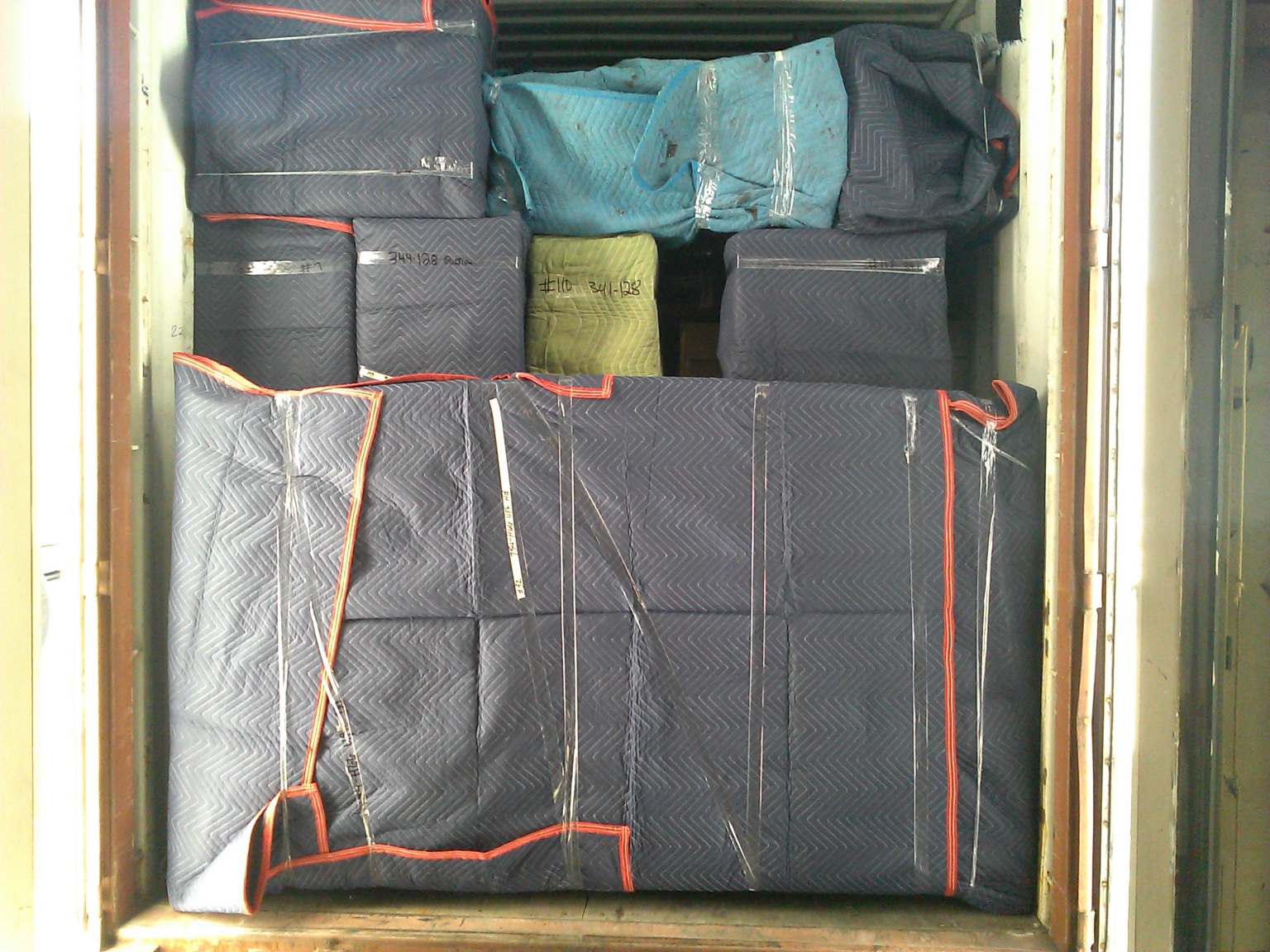 Blanket wrapped furniture secured in truck